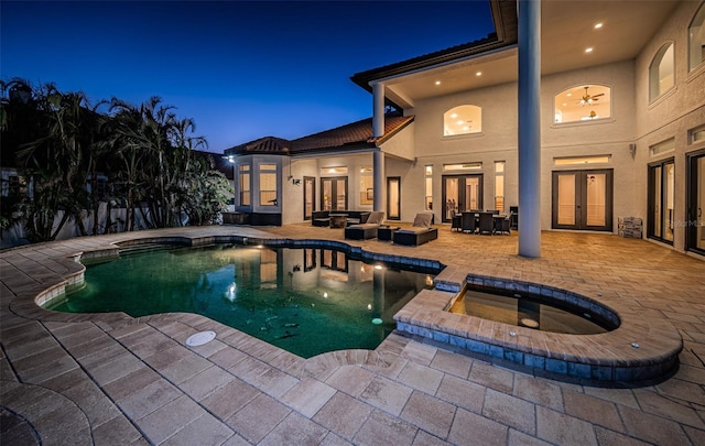 view of swimming pool featuring an in ground hot tub, a patio, french doors, and an outdoor living space with a fire pit