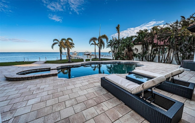 view of pool featuring a patio area, an in ground hot tub, and a water view