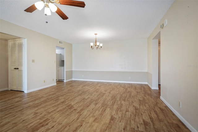 unfurnished room featuring hardwood / wood-style flooring and ceiling fan with notable chandelier