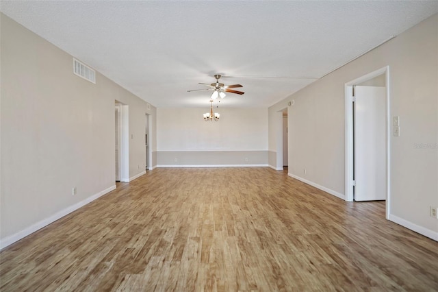 unfurnished room featuring hardwood / wood-style floors, ceiling fan with notable chandelier, and a textured ceiling