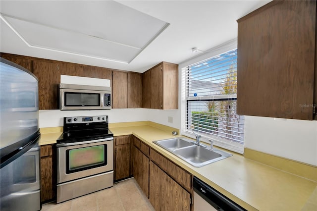 kitchen featuring appliances with stainless steel finishes, sink, and light tile patterned floors