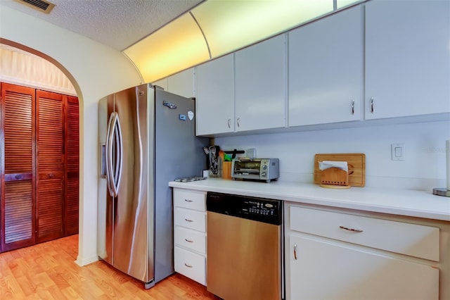 kitchen featuring light hardwood / wood-style flooring, a textured ceiling, and appliances with stainless steel finishes