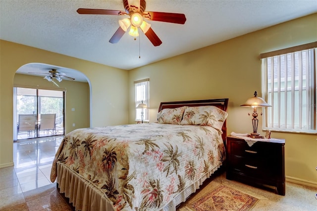 bedroom with multiple windows, access to exterior, a textured ceiling, and ceiling fan