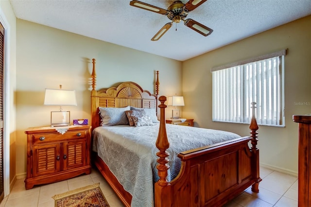 tiled bedroom with ceiling fan and a textured ceiling