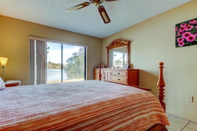 tiled bedroom featuring access to exterior, a textured ceiling, ceiling fan, and a water view