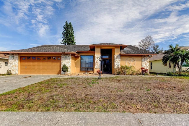 view of front of home with a garage, stone siding, driveway, and stucco siding