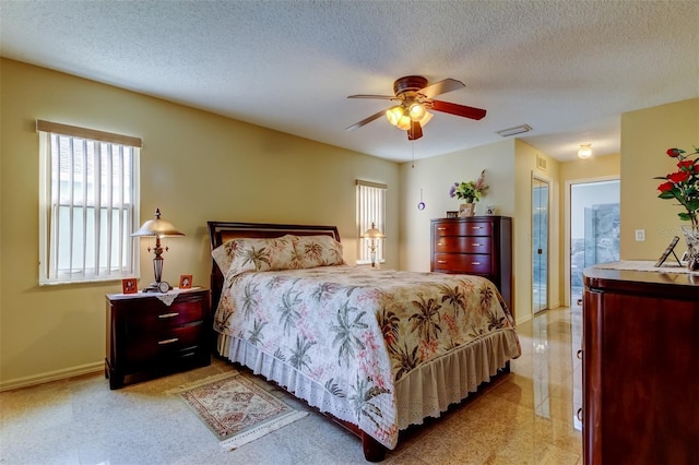 bedroom with visible vents, baseboards, a textured ceiling, and a ceiling fan