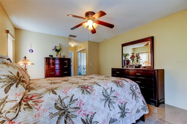 bedroom featuring granite finish floor, visible vents, and a ceiling fan