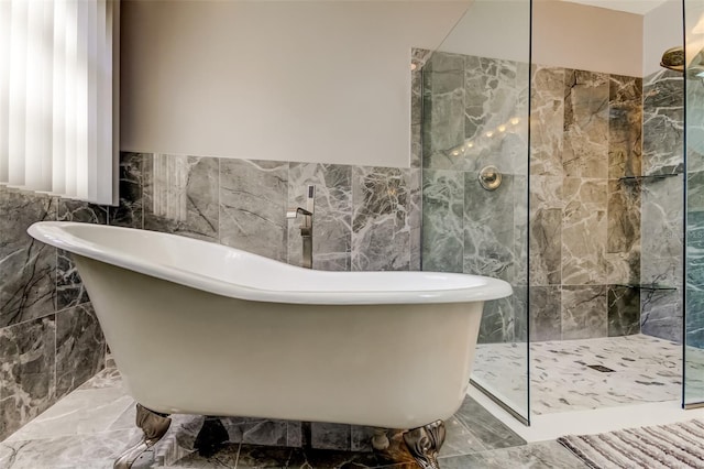 full bath with a soaking tub, tile walls, and a walk in shower