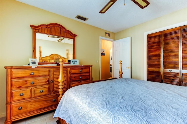 tiled bedroom with visible vents, a closet, and a ceiling fan