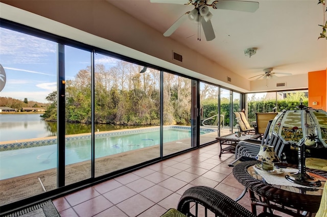 sunroom featuring a water view, visible vents, and a wealth of natural light