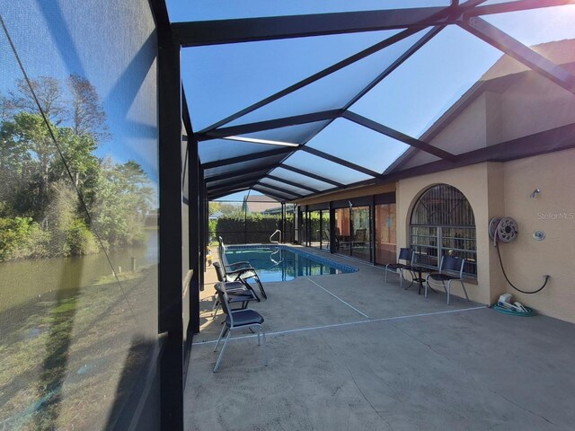 pool with glass enclosure and a patio area