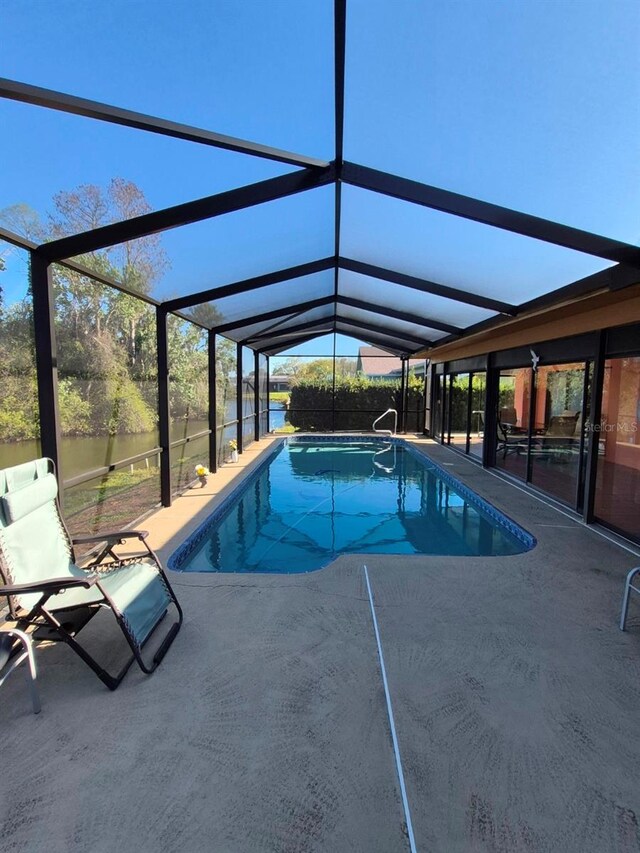 pool featuring glass enclosure and a patio area