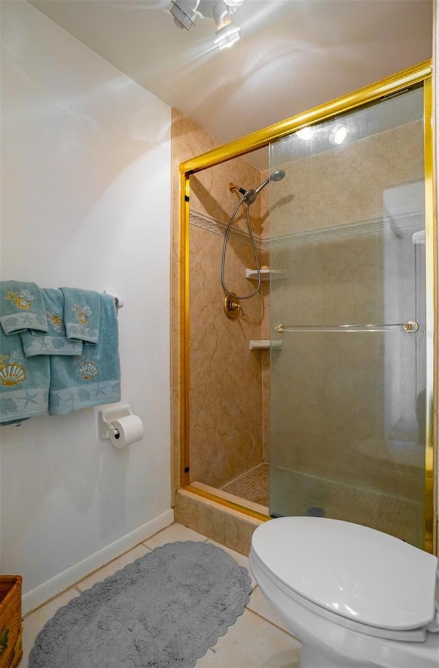 bathroom featuring tile patterned flooring, an enclosed shower, and toilet