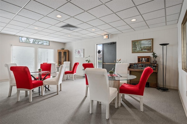 carpeted dining space featuring a drop ceiling