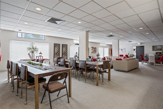 dining space featuring light colored carpet and a drop ceiling