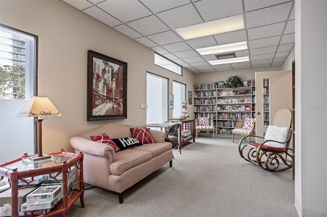 living area with carpet flooring and a drop ceiling