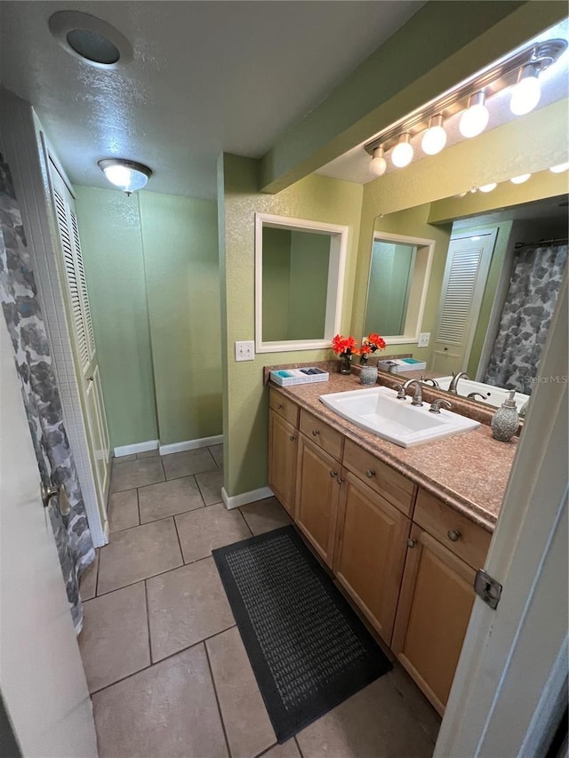 bathroom with tile patterned flooring, vanity, and a textured ceiling