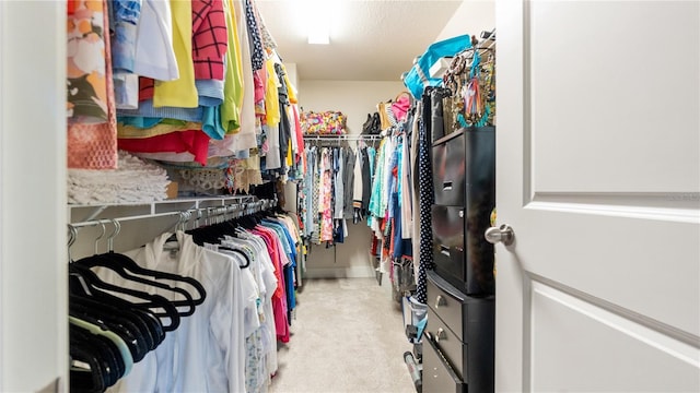 walk in closet with light carpet