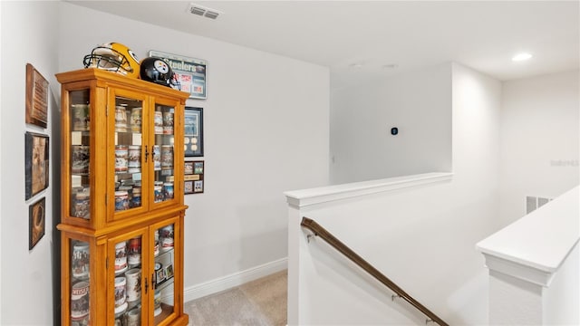 hall featuring light colored carpet