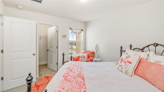 bedroom with a closet, a spacious closet, and light carpet