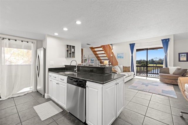 kitchen featuring light tile patterned flooring, sink, white cabinetry, a textured ceiling, and stainless steel appliances