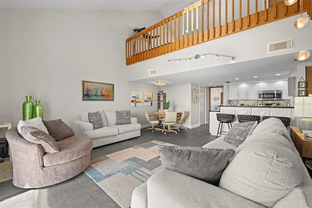 living room featuring a towering ceiling and dark tile patterned floors