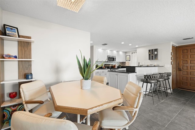 tiled dining room featuring a textured ceiling