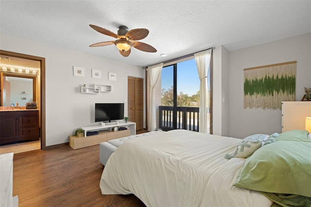 bedroom with ensuite bath, a textured ceiling, access to outside, dark hardwood / wood-style floors, and ceiling fan