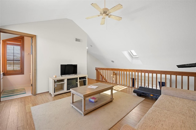 living room with hardwood / wood-style flooring, lofted ceiling with skylight, and ceiling fan