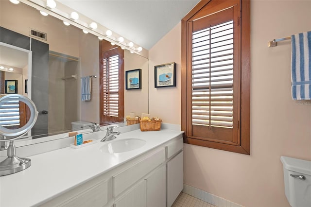 bathroom with vanity, lofted ceiling, tile patterned floors, and toilet