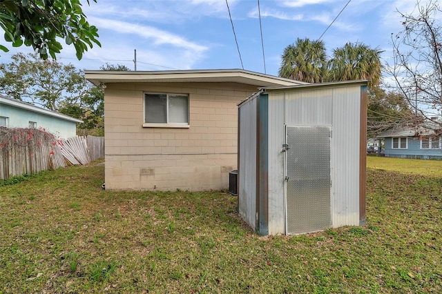 view of outdoor structure with central AC and a lawn