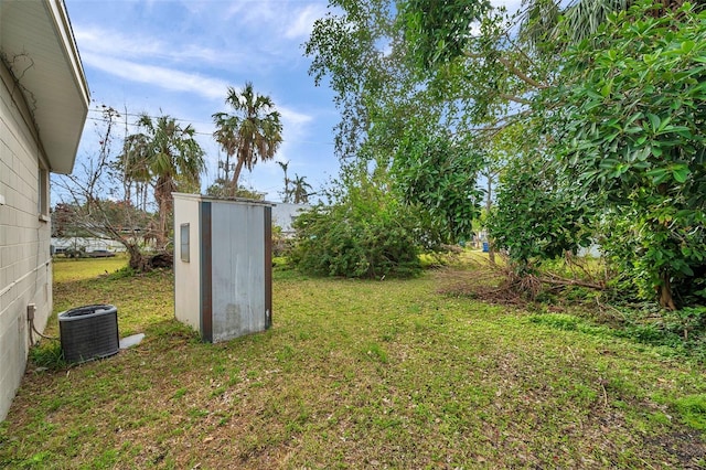 view of yard featuring cooling unit and a storage unit