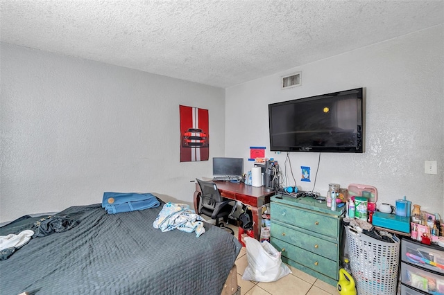 bedroom with a textured ceiling and light tile patterned floors