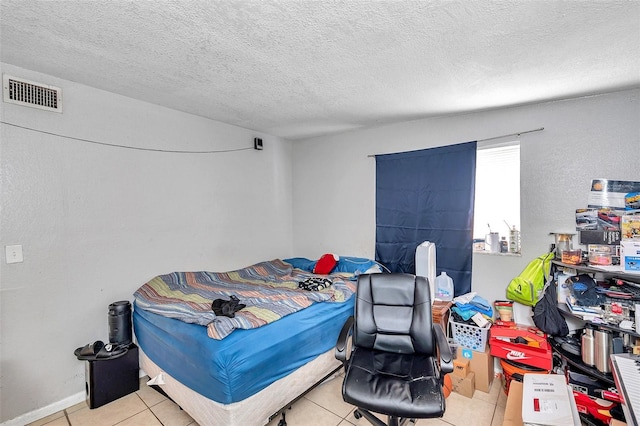 bedroom featuring light tile patterned floors and a textured ceiling