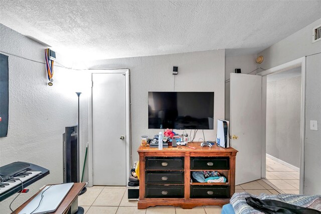 tiled living room featuring a textured ceiling