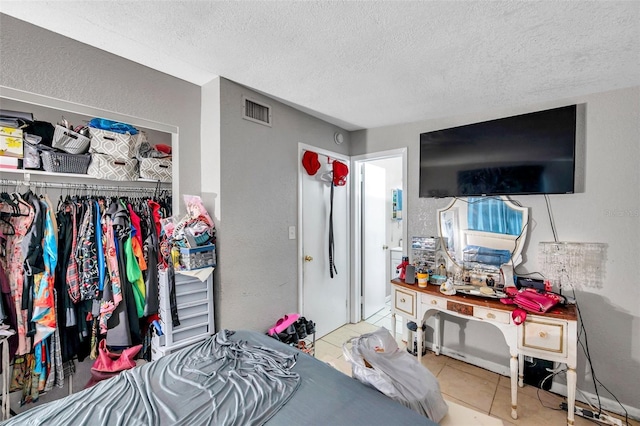 bedroom with a textured ceiling and light tile patterned flooring