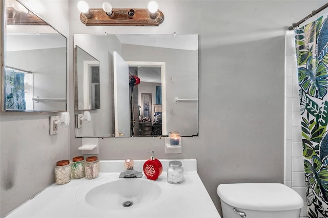 bathroom featuring vanity, toilet, and a shower with shower curtain