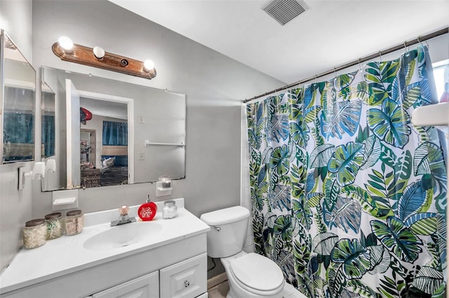 bathroom with vanity, a shower with shower curtain, and toilet