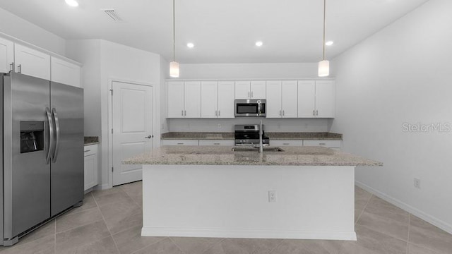 kitchen featuring white cabinetry, stainless steel appliances, and an island with sink