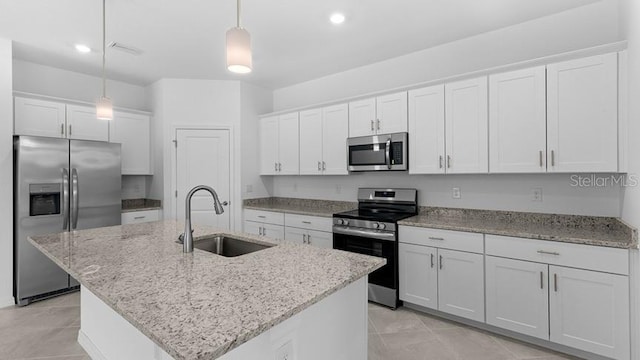 kitchen featuring pendant lighting, sink, white cabinetry, stainless steel appliances, and an island with sink