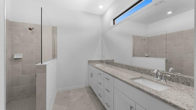 bathroom featuring vanity, a tile shower, and tile patterned floors