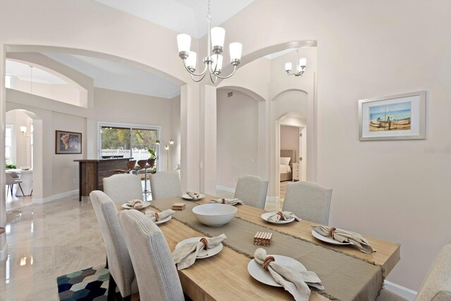 dining room with an inviting chandelier and a high ceiling