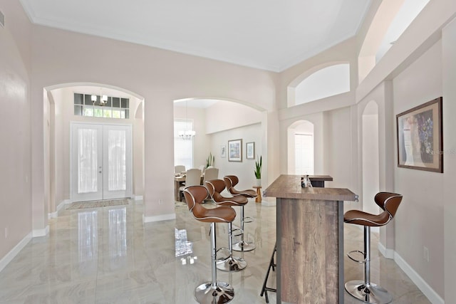 foyer entrance with french doors and a chandelier