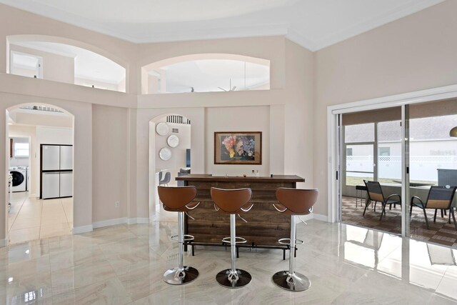 interior space with a high ceiling, washer / dryer, and white fridge