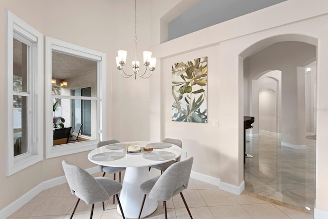 tiled dining area featuring an inviting chandelier