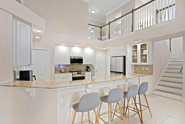 kitchen with kitchen peninsula, white cabinets, and appliances with stainless steel finishes