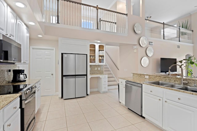 kitchen with white cabinetry, appliances with stainless steel finishes, sink, and light tile patterned floors