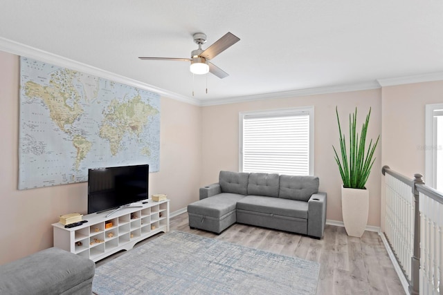 living room with crown molding, ceiling fan, and light wood-type flooring