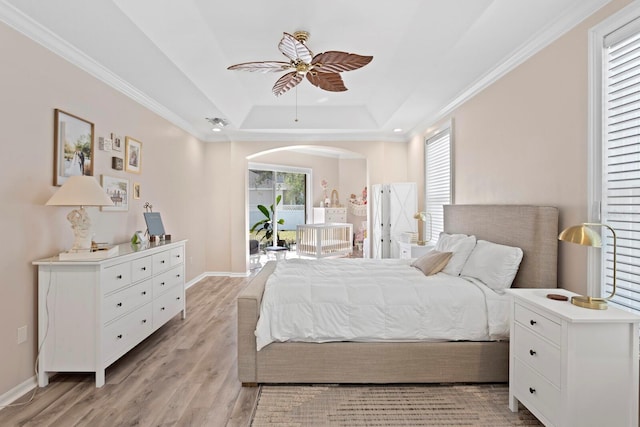 bedroom featuring light hardwood / wood-style flooring, access to outside, ornamental molding, a raised ceiling, and ceiling fan